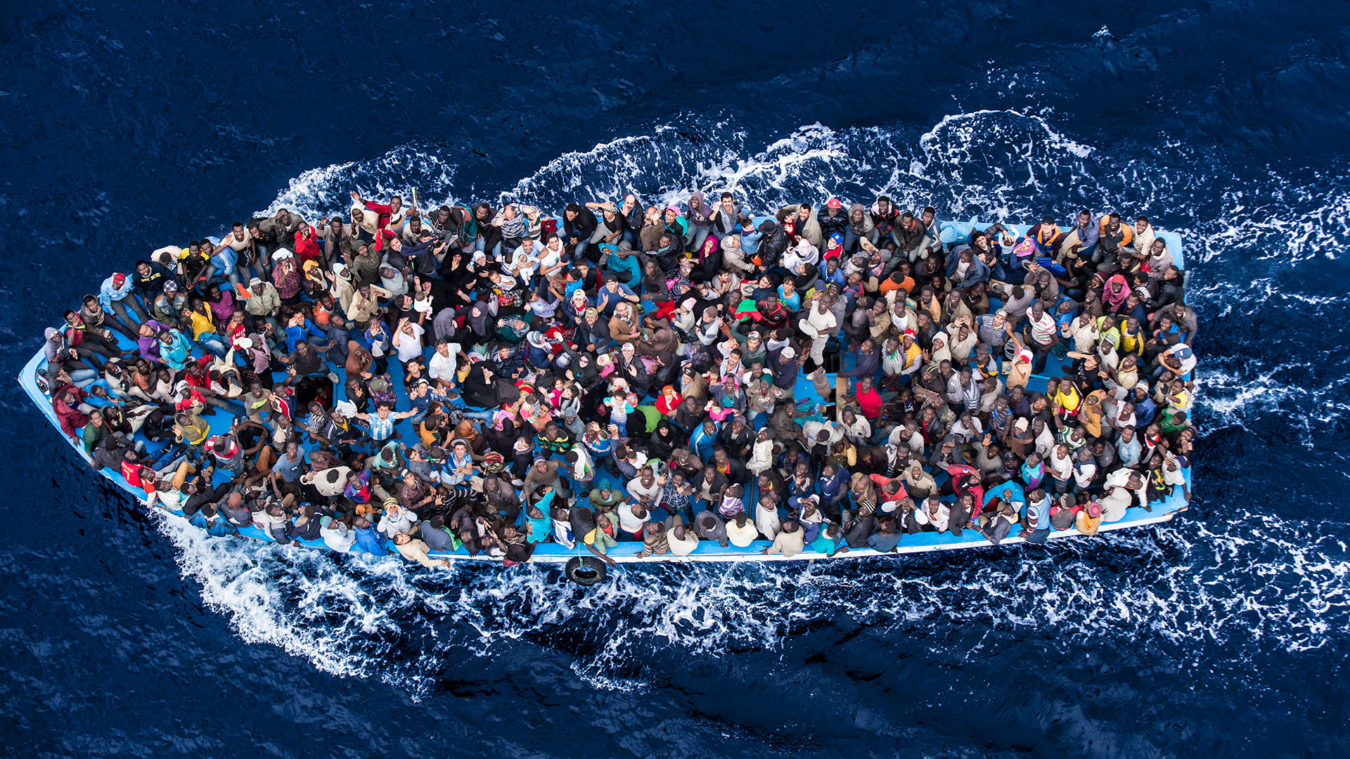 Foto aérea que mostra barco superlotado de refugiados atravessando o mar
