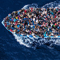 Foto aérea que mostra barco superlotado de refugiados atravessando o mar