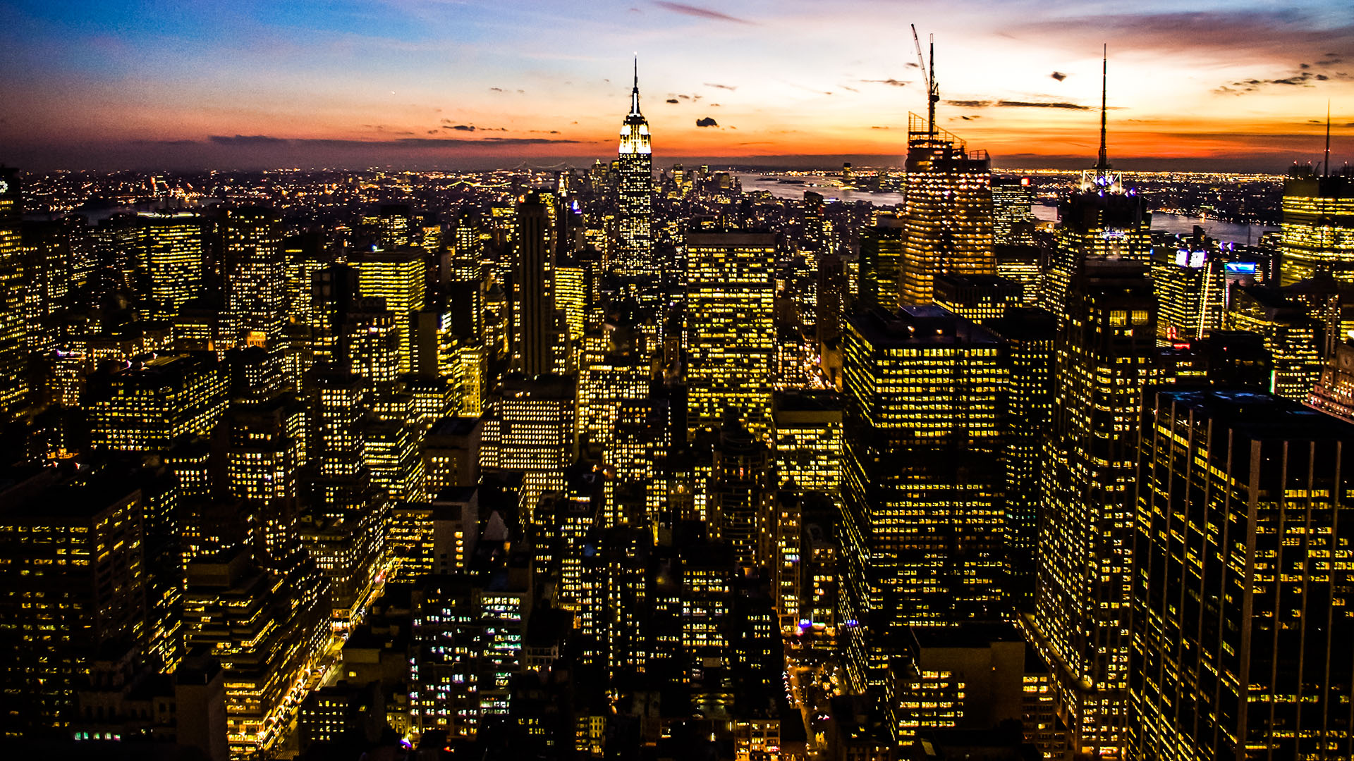 Foto panorâmica de cidade ao anoitecer com muitos prédios iluminados