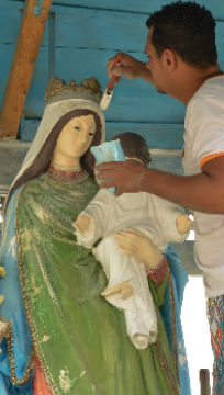 Homem pintando escultura de santo / Foto: Marcos Tristão