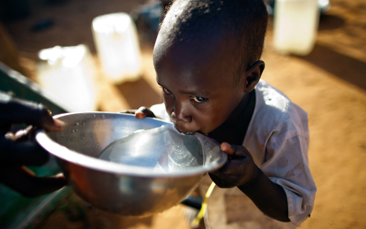 Criança negra bebendo água em uma tigela prata / Foto: United Nations Photo