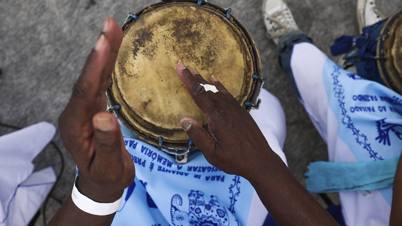 Foto de uma pessoa tocando instrumento musical de percussão