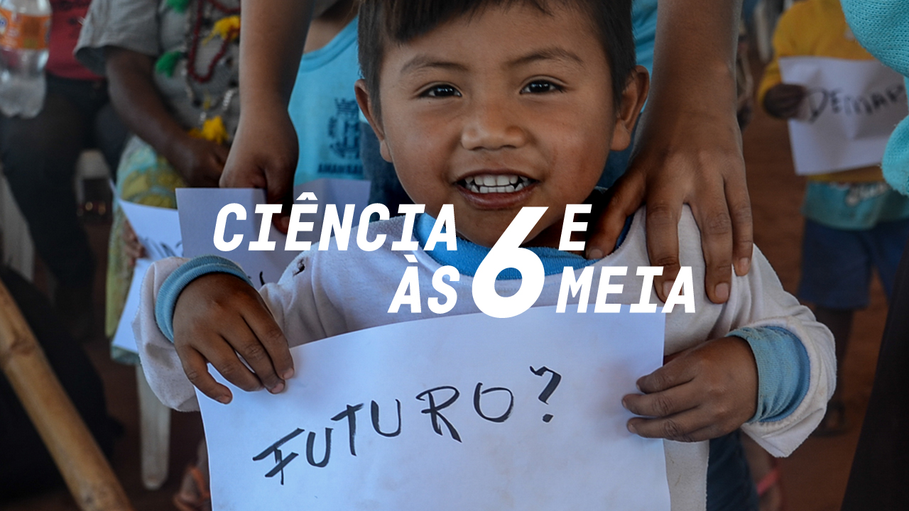 Foto de uma criança indígena segurando um papel escrito "Futuro?"