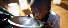 Criança negra bebendo água em uma tigela prata / Foto: United Nations Photo